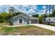 Single-Gathering home with a well-manicured lawn and modern gray exterior at 21310 Quesada Ave, Port Charlotte, FL 33952