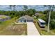 Charming single-story home with gray exterior, complemented by a spacious driveway and well-manicured lawn at 21310 Quesada Ave, Port Charlotte, FL 33952