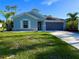 Charming single-story home with blue siding, well-manicured lawn, and a two-car garage at 21310 Quesada Ave, Port Charlotte, FL 33952