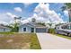 Inviting single-story home with a gray exterior, landscaped front yard and a two-car garage at 21310 Quesada Ave, Port Charlotte, FL 33952