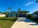 Inviting single-story home featuring a well-manicured lawn, two-car garage, and a long driveway with an RV to the side at 21310 Quesada Ave, Port Charlotte, FL 33952