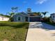 Inviting home featuring a well-manicured lawn, two-car garage, and a long driveway with an RV to the side at 21310 Quesada Ave, Port Charlotte, FL 33952