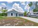Charming single-story home features a gray exterior, two-car garage, and a spacious driveway with a recreational vehicle parked at 21310 Quesada Ave, Port Charlotte, FL 33952
