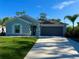 Inviting single-story home featuring a well-manicured lawn and a two-car garage with a long drive at 21310 Quesada Ave, Port Charlotte, FL 33952