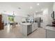 Open-concept kitchen featuring stainless appliances, white cabinets, a quartz island, and seamless flow to dining and living areas at 21310 Quesada Ave, Port Charlotte, FL 33952