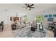 Spacious living room features a plush sofa, a decorative rug, and seamless flow to the dining area at 21310 Quesada Ave, Port Charlotte, FL 33952