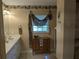 Neutral bathroom with vanity, window, and decorative dresser at 2250 Charleston Park Dr, North Port, FL 34287