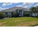 Charming single-story home with a well-manicured lawn and decorative landscaping under a sunny, partly cloudy sky at 2250 Charleston Park Dr, North Port, FL 34287