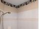 White-tiled shower with hand-held shower head and rose patterned wallpaper at 2250 Charleston Park Dr, North Port, FL 34287