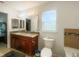 Bright bathroom featuring a double sink vanity with granite countertops, toilet, and tiled shower/bath at 2336 Redfern St, Port Charlotte, FL 33948