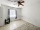 Bedroom featuring neutral tile floors, a ceiling fan, a window with curtains, and a small side table at 2336 Redfern St, Port Charlotte, FL 33948