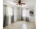 Room with windows, tile flooring, ceiling fan, curtains, and a motivational 
