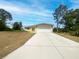Well maintained single-story home with a large driveway and front yard, surrounded by mature trees at 2336 Redfern St, Port Charlotte, FL 33948