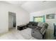 Comfortable living room with tile floors, a sectional couch, and a view to the bathroom at 2336 Redfern St, Port Charlotte, FL 33948
