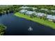 Scenic aerial view of lakeside homes with lush landscaping and a serene fountain, perfect for tranquil living at 25511 Heritage Lake Blvd # 8, Punta Gorda, FL 33983