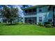 A beautiful exterior view of the building with a screened lanai and lush green lawn at 25511 Heritage Lake Blvd # 8, Punta Gorda, FL 33983