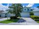 Charming blue two-story townhome featuring a two-car garage, well-maintained lawn, and lush landscaping at 25511 Heritage Lake Blvd # 8, Punta Gorda, FL 33983