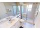 White bathroom featuring a shower with glass enclosure, white vanity and new tile flooring at 26073 Feathersound Dr, Punta Gorda, FL 33955