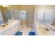 Bathroom featuring a shower with glass enclosure, double sink vanity and new tile flooring at 26073 Feathersound Dr, Punta Gorda, FL 33955
