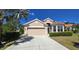 Charming single-story home featuring a tile roof, well-manicured landscaping, and a two-car garage at 26073 Feathersound Dr, Punta Gorda, FL 33955