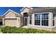 Close-up of a well maintained home with a tile roof, tidy landscaping, and lots of bright windows at 26073 Feathersound Dr, Punta Gorda, FL 33955