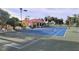 Well-maintained tennis courts with a nearby clubhouse, surrounded by lush greenery, offering a recreational amenity at 26073 Feathersound Dr, Punta Gorda, FL 33955