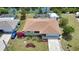 Aerial view of a well-maintained home featuring a garden, a driveway, and a serene canal backdrop at 3080 Saint James St, Port Charlotte, FL 33952
