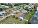 Aerial view of a home with a screened pool, lush trees, and canal access in a residential neighborhood at 3080 Saint James St, Port Charlotte, FL 33952