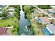 An aerial view displays the backyard waterway, the screened-in lanai and pool, and the surrounding neighborhood at 3080 Saint James St, Port Charlotte, FL 33952