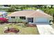 Charming single Gathering home with a well maintained lawn, lovely landscaping, and an attached two car garage at 3080 Saint James St, Port Charlotte, FL 33952