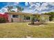 Quaint house featuring colorful landscaping, a spacious driveway, and an attached two car garage for convenience at 3080 Saint James St, Port Charlotte, FL 33952