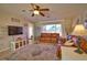 Cozy living room with a ceiling fan, television, and seamless transitions to other living areas at 3080 Saint James St, Port Charlotte, FL 33952