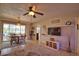 Open living room features a ceiling fan, dining area, and access to the outdoor screened area at 3080 Saint James St, Port Charlotte, FL 33952