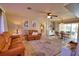 Bright living room featuring leather couches, ceiling fan, and access to the dining area at 3080 Saint James St, Port Charlotte, FL 33952