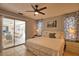 This main bedroom offers a ceiling fan, comfy bed, tile floors, and view of the patio at 3080 Saint James St, Port Charlotte, FL 33952