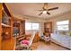 Well-lit home office with built-in bookshelves, a ceiling fan, and comfortable seating, creating an ideal workspace at 3080 Saint James St, Port Charlotte, FL 33952