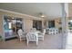 Enclosed patio with tile flooring, ceiling fan, furniture, and sliding glass doors with a view to the backyard at 3080 Saint James St, Port Charlotte, FL 33952