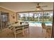 This patio features a fan, table, chairs, and a lovely view of the pool and yard at 3080 Saint James St, Port Charlotte, FL 33952