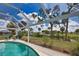 Inviting screened-in pool with lounge chairs, lush landscaping, and an open sky view at 3080 Saint James St, Port Charlotte, FL 33952