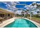 Screened-in pool and lanai area with patio furniture and tropical landscaping, perfect for enjoying the outdoors at 3080 Saint James St, Port Charlotte, FL 33952