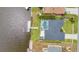 Aerial shot of a house featuring a screened pool, private dock, and waterfront access on a canal at 474 Lomond Dr, Port Charlotte, FL 33953