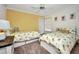 Bright bedroom with two twin beds featuring pineapple-themed bedding and decor, with a sunny yellow accent wall at 474 Lomond Dr, Port Charlotte, FL 33953