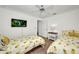 Well-lit bedroom featuring two twin beds with fun, pineapple-themed bedding and a mounted TV on the wall at 474 Lomond Dr, Port Charlotte, FL 33953