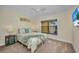 A cozy bedroom with a full bed, calming decor, a ceiling fan, and a TV reflecting the outdoor scenery at 474 Lomond Dr, Port Charlotte, FL 33953