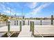 Private wooden dock featuring a boat lift over canal with lush greenery on the opposite shore under blue skies at 474 Lomond Dr, Port Charlotte, FL 33953