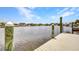 Wooden dock with weathered posts offers a serene waterfront perspective under a partly cloudy sky at 474 Lomond Dr, Port Charlotte, FL 33953