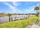 Scenic waterfront view featuring a private dock, lush greenery, and serene water at 474 Lomond Dr, Port Charlotte, FL 33953