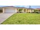 Charming one-story home with a lush green lawn, two-car garage and manicured landscaping at 474 Lomond Dr, Port Charlotte, FL 33953