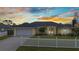 Charming home featuring a lovely lawn, white picket fence, attached garage, and meticulously landscaped front yard at 474 Lomond Dr, Port Charlotte, FL 33953