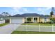 Exterior view of the property, complete with a two-car garage, fenced yard, and meticulously maintained lawn at 474 Lomond Dr, Port Charlotte, FL 33953